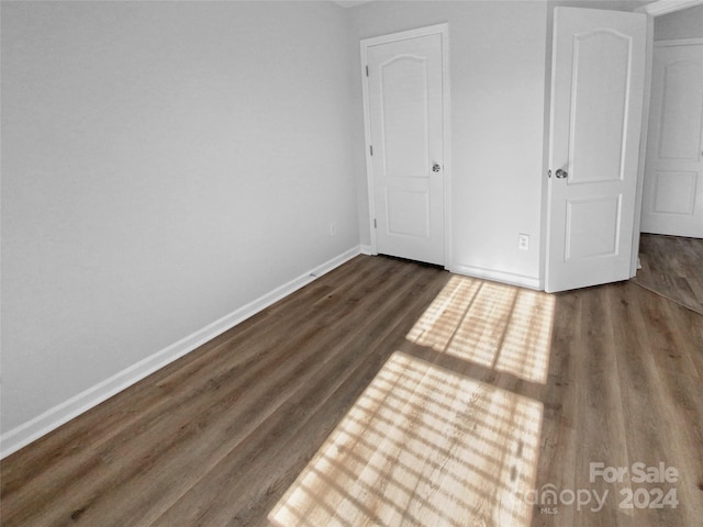 unfurnished bedroom with dark wood-type flooring