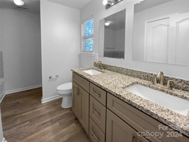 bathroom featuring wood-type flooring, vanity, and toilet