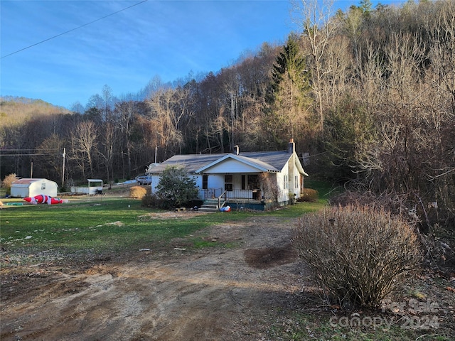 ranch-style house featuring covered porch and a front lawn