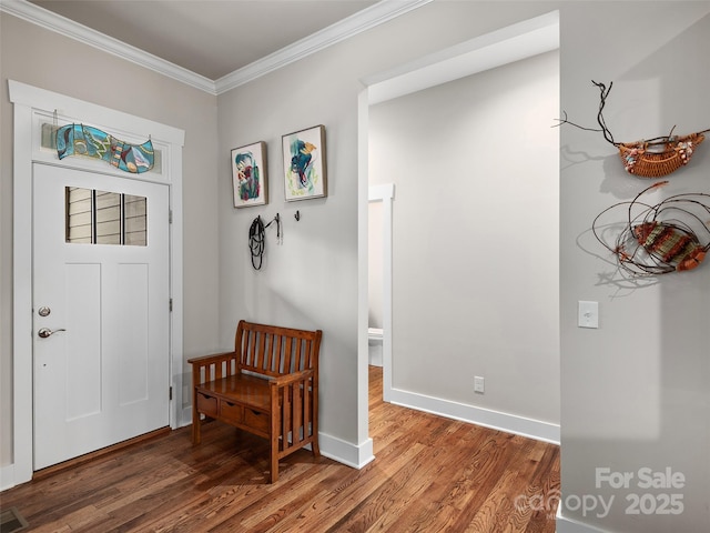 foyer entrance with baseboards, wood finished floors, visible vents, and crown molding