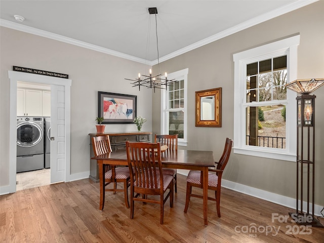 dining space featuring crown molding, a notable chandelier, independent washer and dryer, and wood finished floors