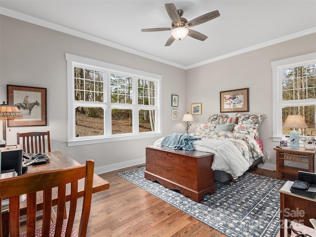 bedroom featuring ornamental molding, multiple windows, and light wood-type flooring