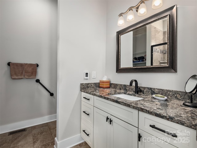 bathroom featuring baseboards, visible vents, and vanity