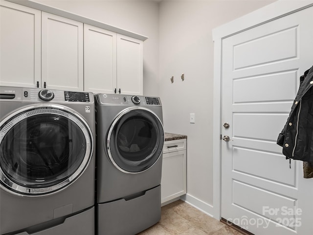 washroom with independent washer and dryer, cabinet space, and baseboards