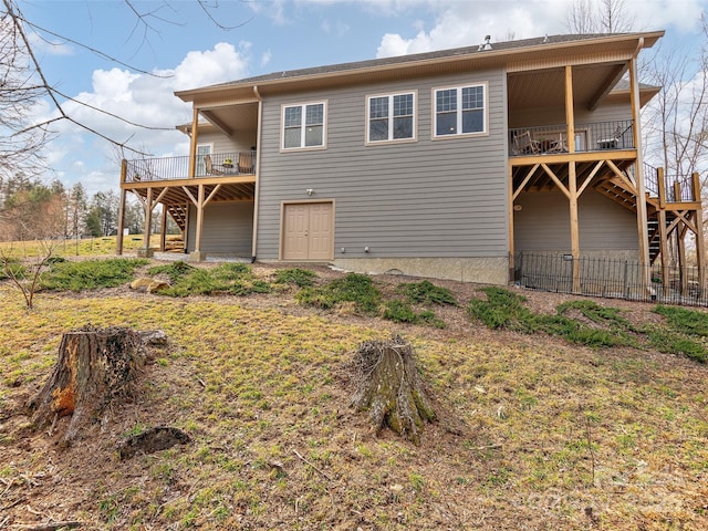 back of property with stairs, a deck, and fence