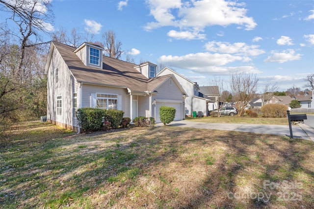 cape cod house with driveway, an attached garage, and a front lawn