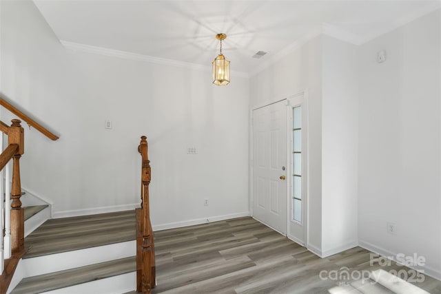 entrance foyer with visible vents, ornamental molding, wood finished floors, stairway, and baseboards