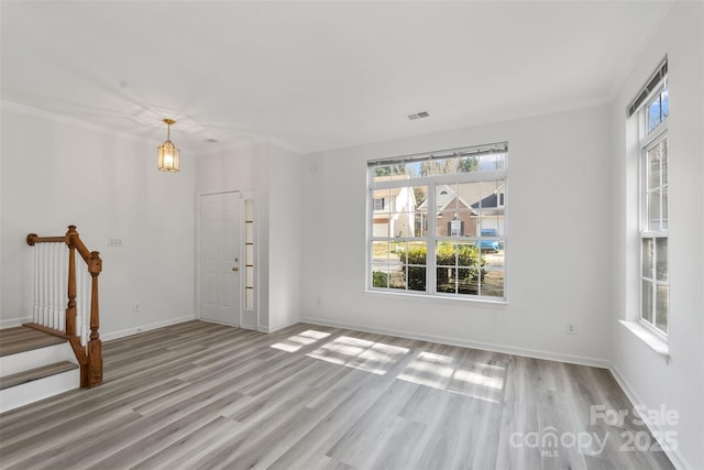 foyer entrance with wood finished floors, visible vents, baseboards, stairs, and a chandelier