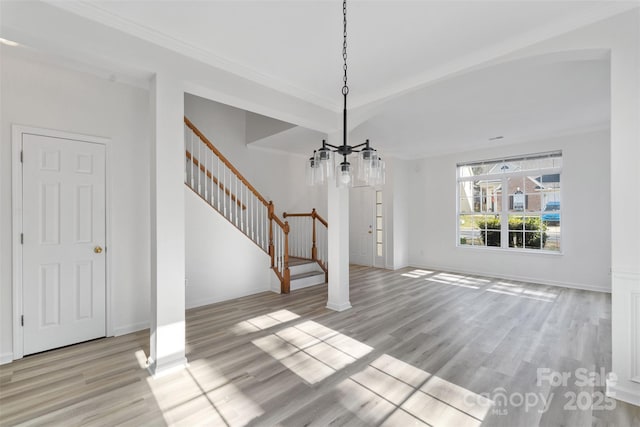 unfurnished dining area with stairs, wood finished floors, baseboards, and ornamental molding