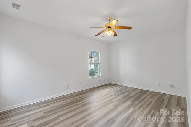 spare room featuring visible vents, baseboards, light wood-style flooring, and a ceiling fan