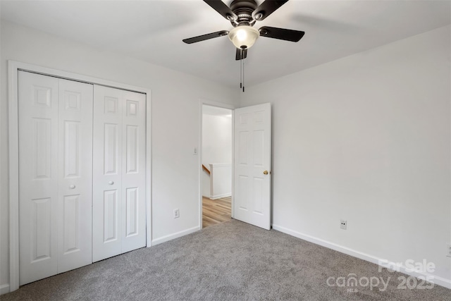 unfurnished bedroom with a closet, baseboards, a ceiling fan, and carpet flooring