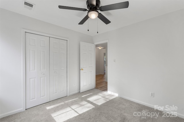 unfurnished bedroom with a closet, visible vents, baseboards, and carpet floors