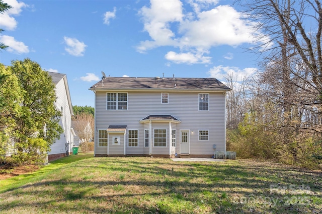 rear view of property featuring a patio and a yard