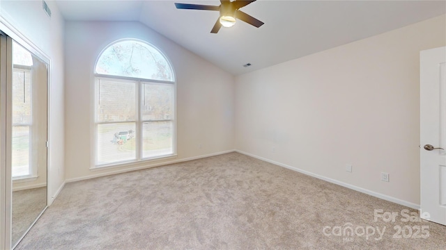 empty room with light colored carpet, ceiling fan, and lofted ceiling