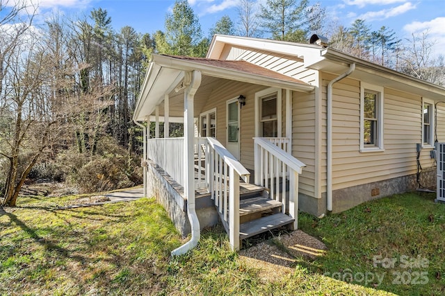 view of home's exterior featuring covered porch and a yard