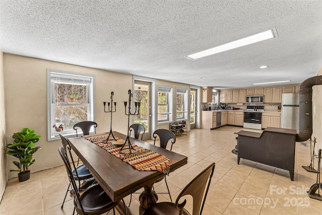 dining area with light tile patterned floors and a textured ceiling