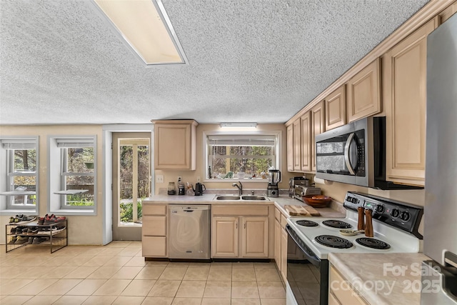 kitchen featuring a wealth of natural light, stainless steel appliances, sink, light tile patterned floors, and light brown cabinets