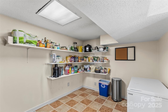 interior space with light tile patterned floors, a textured ceiling, and independent washer and dryer