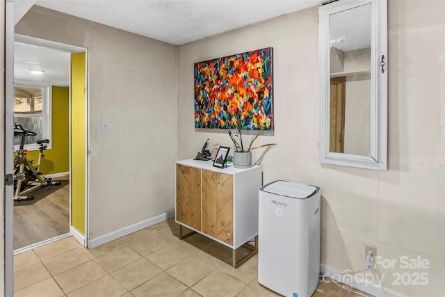 interior space featuring light tile patterned flooring and a textured ceiling