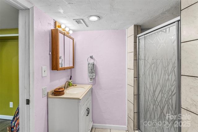 bathroom with vanity and a shower with door