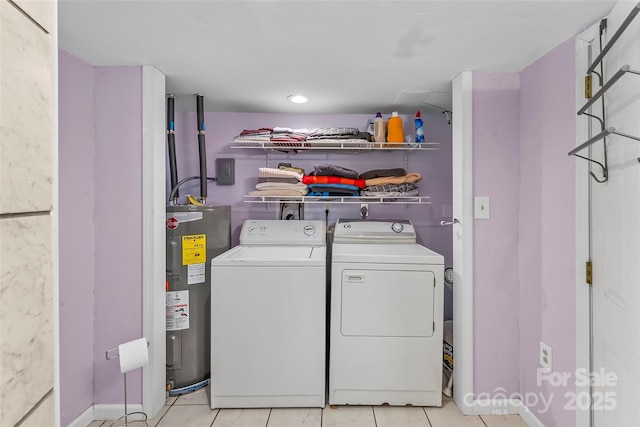 laundry room featuring washing machine and clothes dryer, light tile patterned floors, and water heater