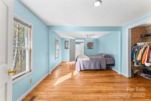 bedroom featuring a textured ceiling, light hardwood / wood-style floors, and a closet