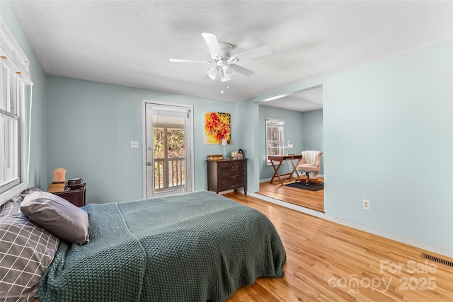 bedroom with ceiling fan, a textured ceiling, and hardwood / wood-style flooring