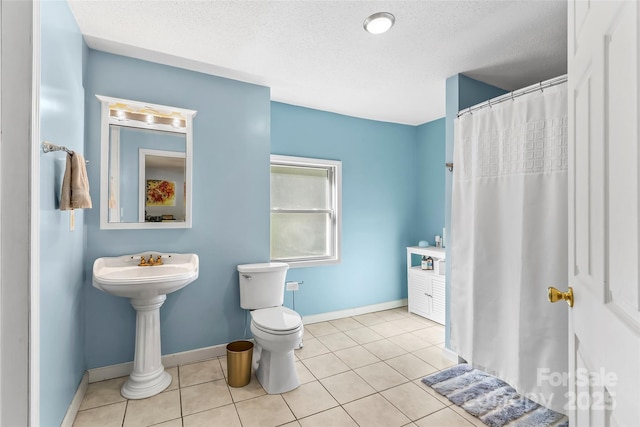 bathroom featuring tile patterned flooring, a textured ceiling, toilet, and a shower with shower curtain