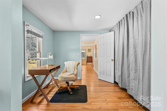 living area with light wood-type flooring and a textured ceiling