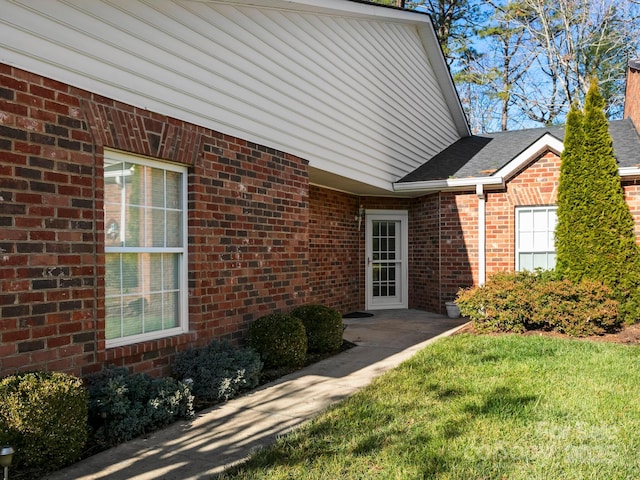 doorway to property with a lawn