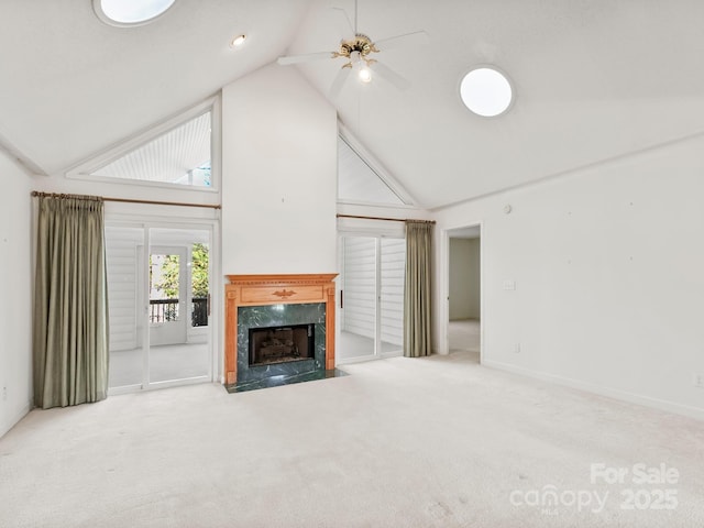 unfurnished living room featuring ceiling fan, a high end fireplace, carpet floors, and high vaulted ceiling