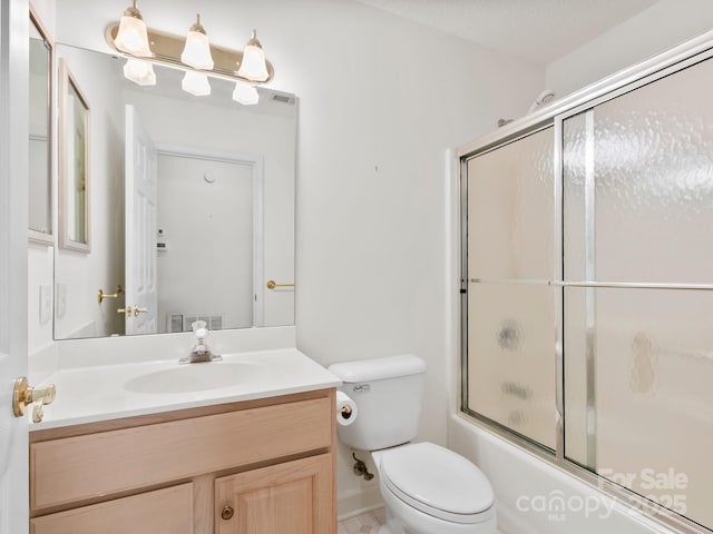 full bathroom with vanity, toilet, and bath / shower combo with glass door