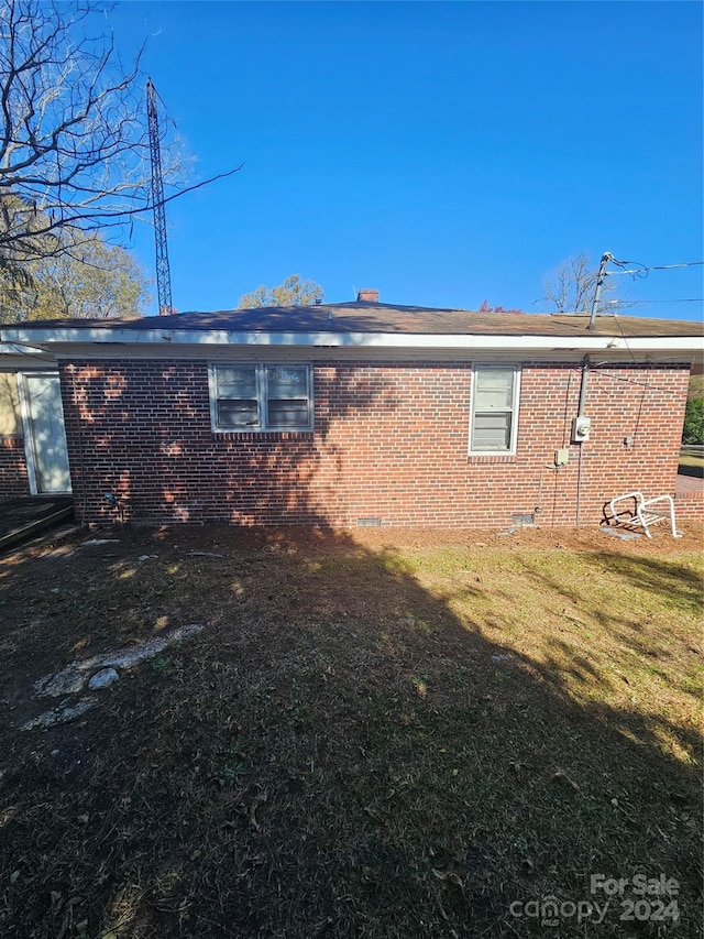 back of house with a lawn