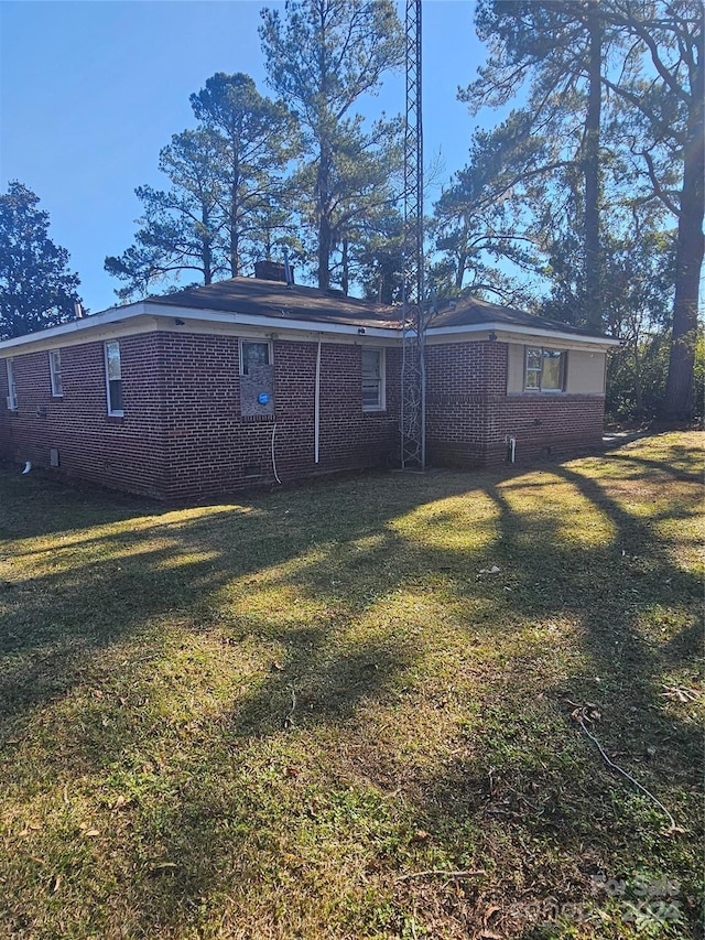 rear view of property featuring a lawn