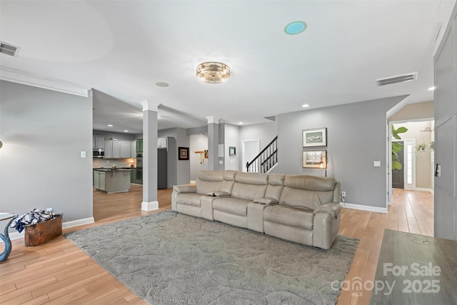 living room featuring decorative columns and light hardwood / wood-style floors