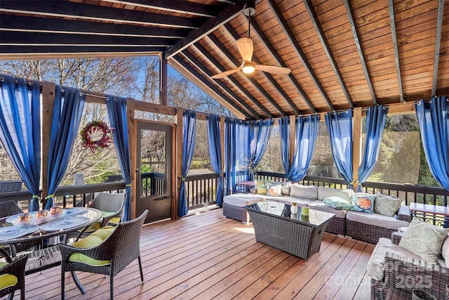 sunroom featuring lofted ceiling with beams, wooden ceiling, and ceiling fan