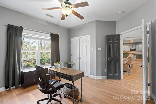 office with ceiling fan and light hardwood / wood-style flooring