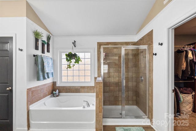 bathroom featuring lofted ceiling and plus walk in shower