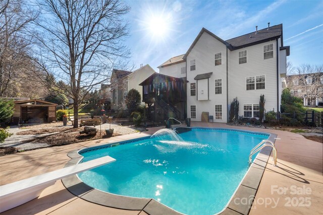 view of pool featuring a diving board, pool water feature, and a patio area