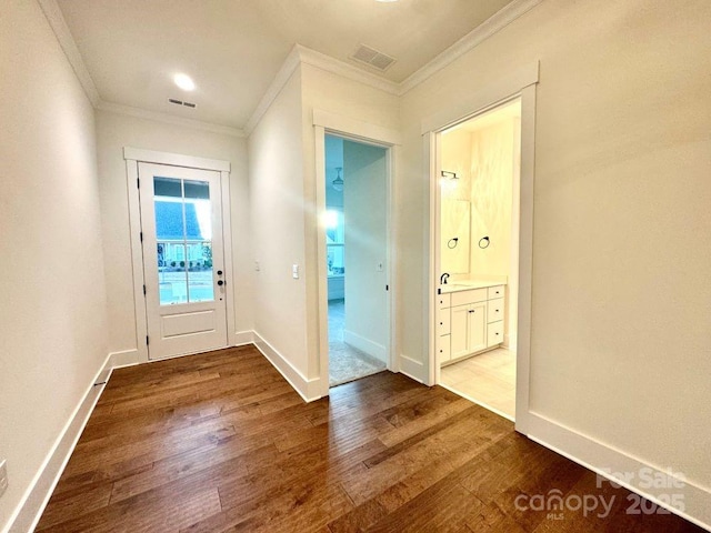 doorway to outside featuring hardwood / wood-style flooring and crown molding