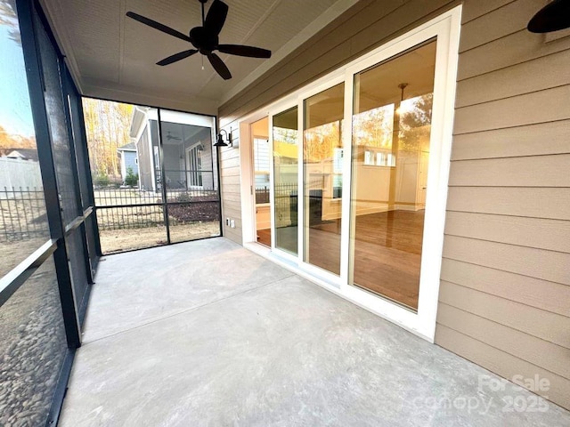 unfurnished sunroom with ceiling fan