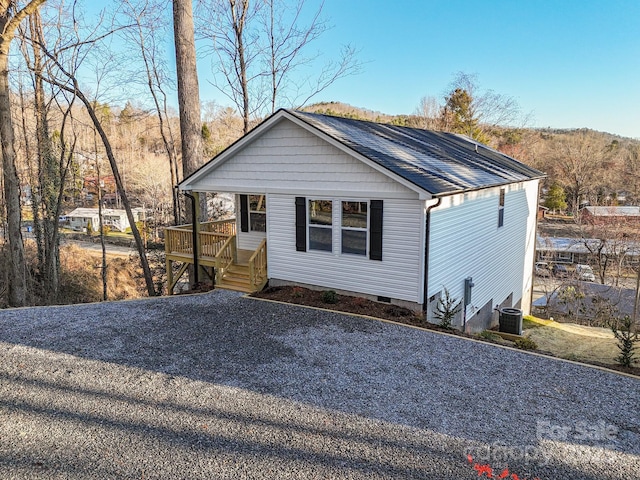 view of front of property featuring central air condition unit and a shingled roof