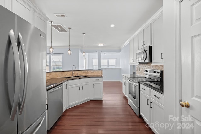 kitchen with sink, white cabinets, pendant lighting, and appliances with stainless steel finishes