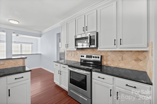 kitchen featuring white cabinetry, stainless steel appliances, dark hardwood / wood-style flooring, backsplash, and ornamental molding