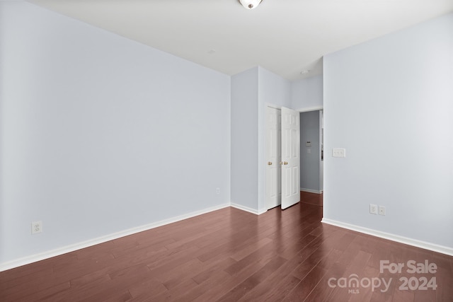 spare room with dark wood-type flooring