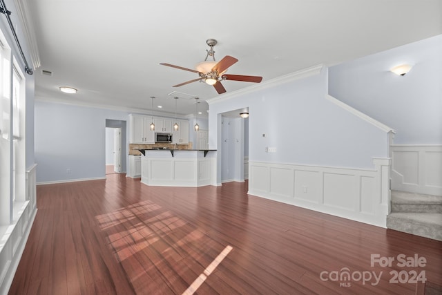 unfurnished living room with dark hardwood / wood-style floors, ceiling fan, and crown molding