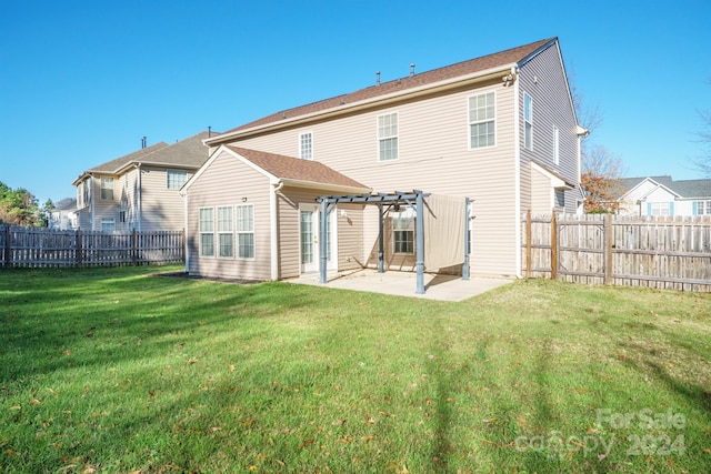 rear view of property featuring a pergola, a yard, and a patio