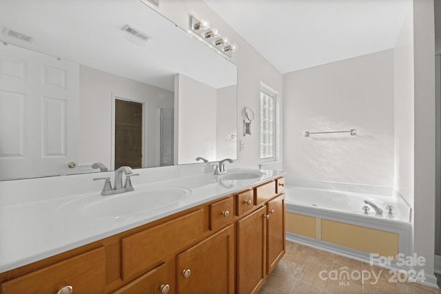 bathroom featuring vanity, tile patterned floors, and a bathtub