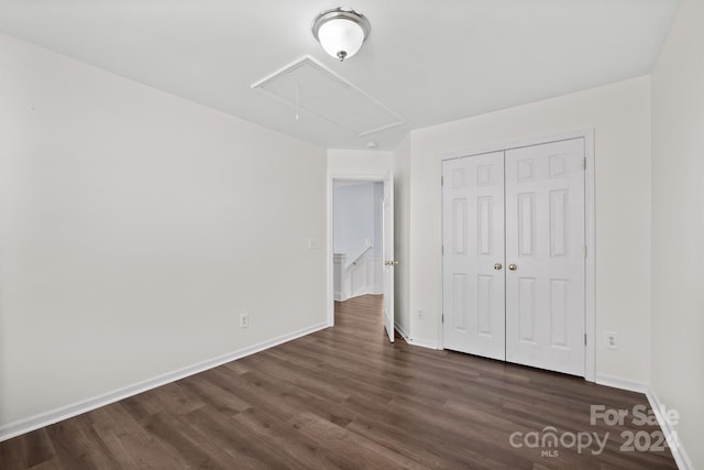 unfurnished bedroom with dark hardwood / wood-style flooring and a closet