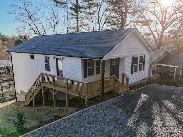 rear view of property featuring crawl space, roof with shingles, and a deck